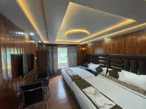 a hotel room with two beds and a television at Hotel Sounsar and Restaurant in Sonāmarg