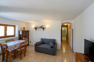 a living room with a table and a couch and a television at Casa Flory in Verbania