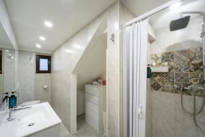 a white bathroom with a shower and a sink at Casa Flory in Verbania +16 photos