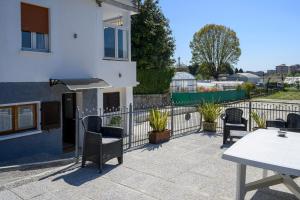 a patio with chairs and a table and a fence at Casa Flory in Verbania
