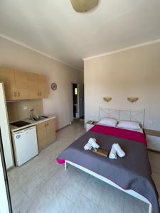 a bedroom with a large bed with two towels at Asprovalta Rooms in Asprovalta