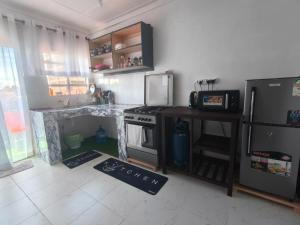a kitchen with a stove and a refrigerator at Meg Cozy Homes Executive 1Bedroom and 2Bedroom Apartments Near Rupa Mall The Noble Hotel & Poa Place Resort in Eldoret +11 photos