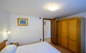 a bedroom with a bed and a wooden closet at Casa Flory in Verbania