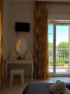 a bedroom with a dressing table with a mirror and a window at Asprovalta Rooms in Asprovalta