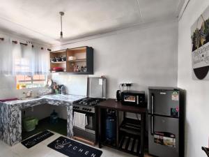 a small kitchen with a stove and a refrigerator at Meg Cozy Homes Executive 1Bedroom and 2Bedroom Apartments Near Rupa Mall The Noble Hotel & Poa Place Resort in Eldoret