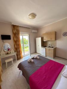 a bedroom with a large bed and a kitchen at Asprovalta Rooms in Asprovalta