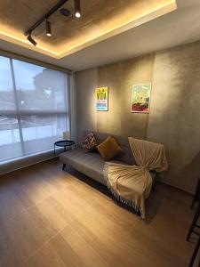 a living room with a couch and a large window at MOCA Living in Cali
