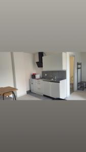 a kitchen with white cabinets and a wooden table at Apartment zoe in Erny-Saint-Julien