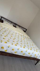 a bed with yellow and white sheets on it at Apartment zoe in Erny-Saint-Julien