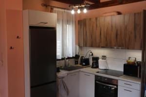 a kitchen with white cabinets and a black refrigerator at Villa Milea in Milies Pelion in Mileai +28 photos