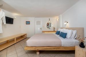 a bedroom with a large bed with blue pillows at Villa by Hotel Thira in Fira +31 photos