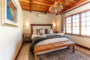 a bedroom with a large bed and a chandelier at Nassau Guest Farm in Stellenbosch +136 photos