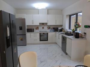 a kitchen with white appliances and white cabinets at Hotel vibe at home in Edenderry