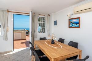 a dining room with a wooden table and chairs at Villa by Hotel Thira in Fira