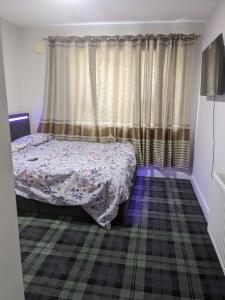 a bedroom with a bed and a window with curtains at Hotel vibe at home in Edenderry
