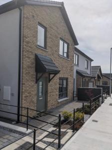 a brick house with a black awning on it at Hotel vibe at home in Edenderry