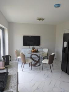 a dining room with a table and chairs and a tv at Hotel vibe at home in Edenderry