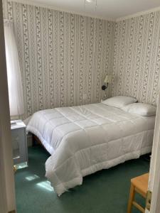 a bedroom with a large bed with white sheets at Beach Block Victorian 1 minute from beach in Ventnor City