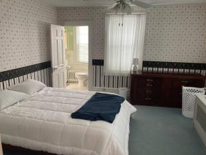 a bedroom with a large white bed and a window at Beach Block Victorian 1 minute from beach in Ventnor City +8 photos