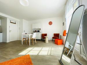 a living room with a table and chairs and a kitchen at Hyper centre, rue piétonne, calme et lumineux in Dijon
