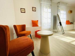 a living room with a chair and a table at Hyper centre, rue piétonne, calme et lumineux in Dijon +8 photos