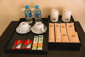 a tray with a tea set and bottles of water at Tràng An Valley Garden in Ninh Binh