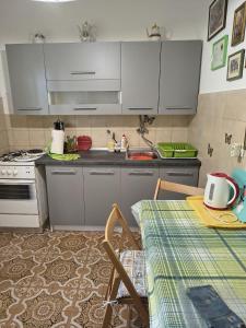 a kitchen with white cabinets and a table with a table sidx sidx at Apartment Sanka in Gdinj