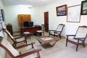a living room with rocking chairs and a table at Diani cozy cottage camp in Diani Beach