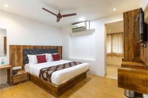 a bedroom with a large bed and a television at Hotel Suites Inn in Mumbai