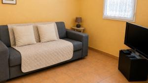 a living room with a couch and a flat screen tv at Gîte Valensole in Valensole