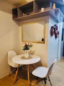 a table and two chairs and a vase with flowers at The Loop Towers Limketkai in Pontud