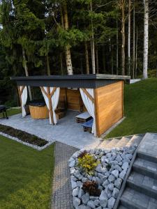 a pavilion with a bench in a garden at Domek letniskowy Leśne Zacisze- jacuzzi, balia ogrodowa, grill i altana in Słopnice