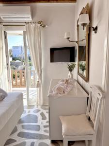 a bedroom with a desk and a bed and a mirror at Villa ELAYA in Mikonos