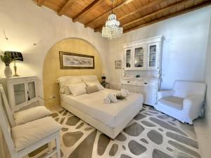 a bedroom with a white bed and a chair at Villa ELAYA in Mikonos +30 photos