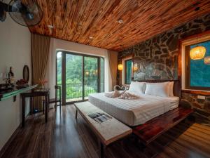 a bedroom with a bed and a stone wall at Tam Coc Haven House in Ninh Binh