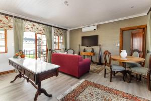a living room with a red couch and a table at Nassau Guest Farm in Stellenbosch