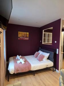 a bedroom with a large bed with purple walls at Auberge Restaurant du Virage in Chamrousse