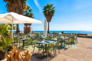 a restaurant with tables and chairs and the beach at You and the Sea in Savona