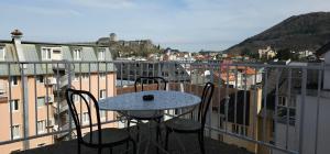 a table and chairs on a balcony with a view at Hotel CÖRONA Lourdes in Lourdes