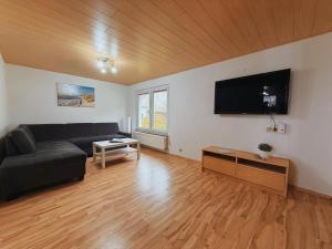 a living room with a couch and a flat screen tv at Ferienwohnung 2 Wald & See in Zirchow