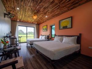 a bedroom with orange walls and a bed and a couch at Tam Coc Haven House in Ninh Binh