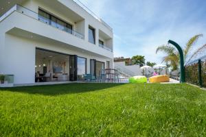 a white house with a yard with green grass at Villa Cosmo Panorama in Rrashbull