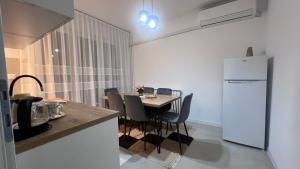a kitchen with a table with chairs and a refrigerator at Apartman Mešanović in Tuzla +4 photos