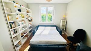 a bedroom with a bed in a room with bookshelves at Les hauteurs d'Avon - Vue forêt - Parking in Avon