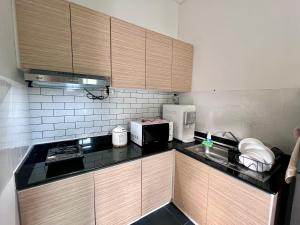 a kitchen with wooden cabinets and a black counter top at The sea forest in Ban Nong Sanom +3 photos