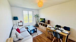 a living room with a couch and a table at Les hauteurs d'Avon - Vue forêt - Parking in Avon