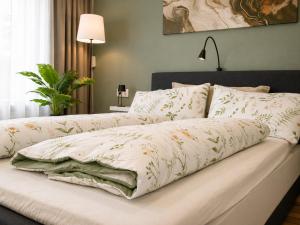 a bed with white comforter and pillows on it at Haus Madeleine in Schönwald