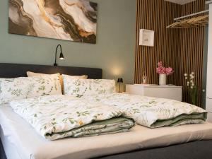 a bed with a blanket on it in a bedroom at Haus Madeleine in Schönwald