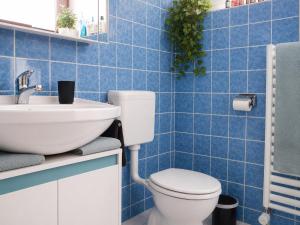 a blue tiled bathroom with a toilet and a sink at Haus Madeleine in Schönwald +32 photos