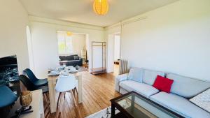 a living room with a couch and a table at Les hauteurs d'Avon - Vue forêt - Parking in Avon